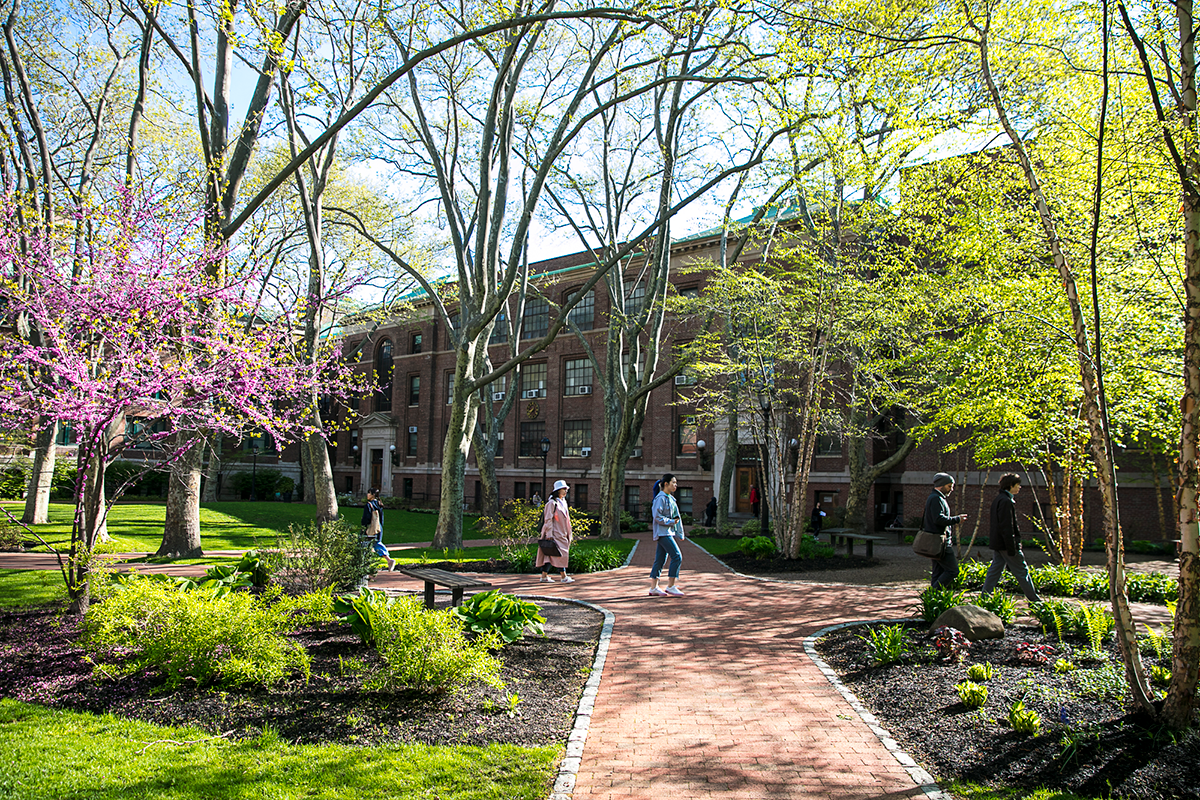 Outside, campus in spring time with students walking around
