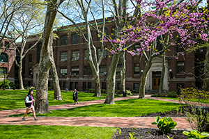 Outside, campus in spring time with students walking around