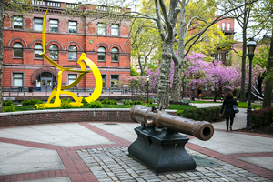 Outside campus, yellow abstract sculpture and a cannon