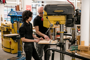 tacher and student at heavy equipment in a classroom studio